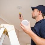 Man Checking Smoke Alarm on Ceiling