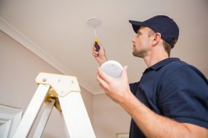 Man Checking Smoke Alarm on Ceiling