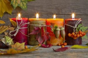 Burning Candles on Wooden Table Decorated for Fall