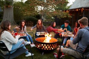 Friends sitting around a backyard fire